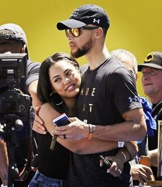 a man and woman embracing each other in front of cameras