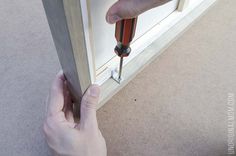 a person using a screwdriver to fix a window sealer on a door