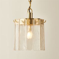 a light fixture with three glass shades hanging from it's brass frame and chain