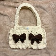 a crocheted purse with brown bows on it