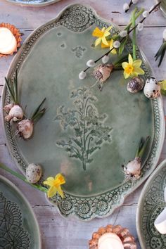 a table topped with plates filled with flowers and candles