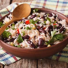 a bowl filled with rice, beans and cilantro on top of a table