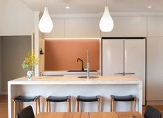 a kitchen with an island and four stools next to the counter top that has a sink on it