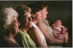 an older woman and two younger women holding a baby