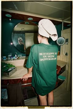 a young man wearing a green shirt and white hat in front of a mirror with the words be as happy as you seem on instagram