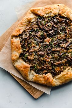 a pizza with mushrooms and herbs on it