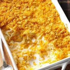 a casserole dish with cheese and bread crumbs in it on a wooden table