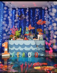 an under the sea themed birthday party with balloons and streamers on the ceiling, fish decorations