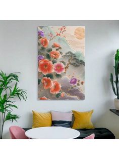 a painting hanging on the wall above a white table with pink chairs and yellow pillows