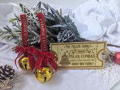 two christmas ornaments and a plaque on a table