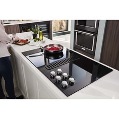 a black and white kitchen with an oven, stove top and counter tops in it