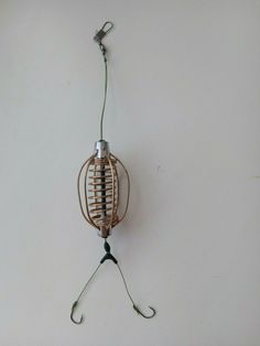 a bird cage hanging from the side of a wall with wires attached to it's sides