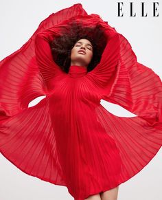 a woman in a red dress with her hands on her head and arms behind her head