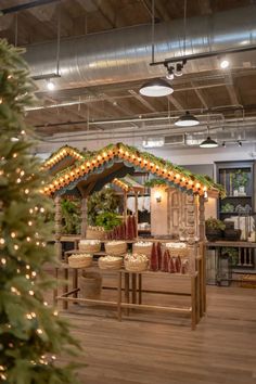 a christmas display in a store with lights on the roof and decorations hanging from the ceiling