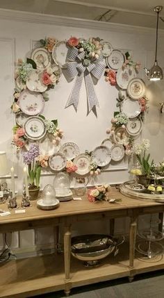 a table topped with plates covered in flowers next to a wall mounted art piece that reads pine tree barn's post