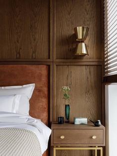 a bedroom with wood paneling and white bedding, along with two nightstands