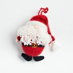 a knitted santa clause ornament hanging on a white wall