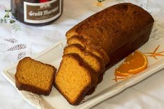 a loaf of bread sitting on top of a white plate next to an orange slice