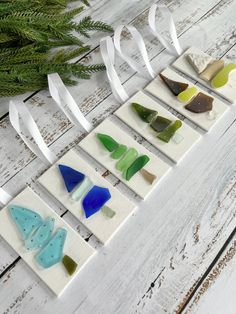 several pieces of glass sitting on top of a white wooden table next to a plant