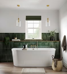 a white bath tub sitting under a window next to a rug on the wooden floor