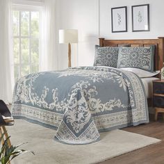 a bed with blue and white bedspread in a bedroom