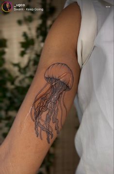 a woman's arm with a tattoo of a jellyfish