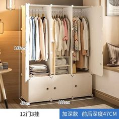 an open closet with clothes hanging on the door and drawers in it, next to a table