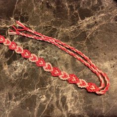 a red and white braided rope on top of a marble slab with black background