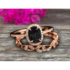 two rose gold wedding rings with an oval black diamond