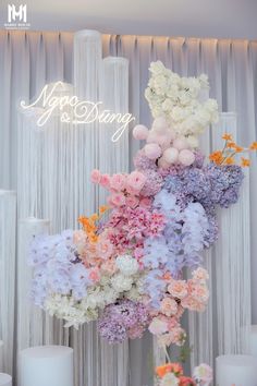 an arrangement of flowers and candles are displayed in front of a backdrop with the words happy birthday on it