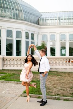 a man and woman dancing in front of a building