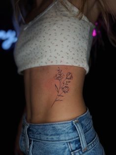 a woman with a flower tattoo on her stomach