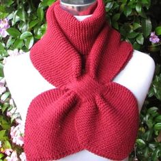 a red knitted scarf sitting on top of a mannequin's head