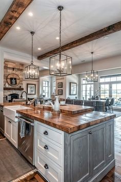 a kitchen with an island in the middle of it and lots of lights hanging from the ceiling