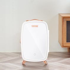 a white suitcase sitting on top of a hard wood floor next to a wooden cabinet