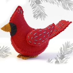 a red felt bird sitting on top of a white table