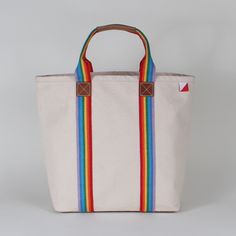 Our Society Tote Bag is an instant classic. Rainbow striped cotton webbing highlight the bag from bottom to top. And there's a full leather bottom too. Our crisp heavyweight natural canvas gives this bag a lot of structure. A super chic everyday bag. Crafted with heavyweight cotton canvas Nubuck leather details on the strap and full bottom Metal stud detail Size: 20" x 15.5" x 5.5" Interior pocket 20" x 15.5" x 5.5". Michigan Sticker, Navy Embroidery, Black Fig, Monogram Styles, Bees Knees, Pencil Pouch, Nubuck Leather, Everyday Bag, Rainbow Stripes