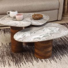 two coffee tables sitting on top of each other in front of a couch and rug