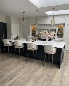 a large kitchen with an island and bar stools next to the counter top in front of it