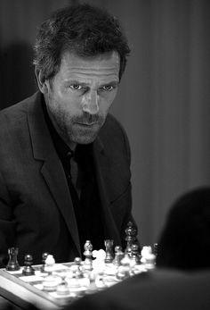 a man in a suit playing chess