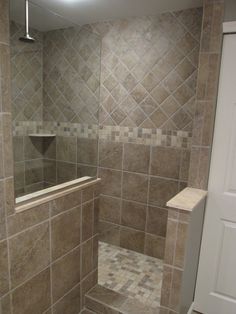 a walk in shower sitting inside of a bathroom next to a white door and window