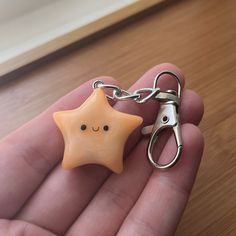 a hand holding a small star shaped keychain