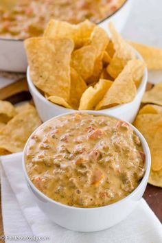 two white bowls filled with salsa and tortilla chips on top of a table