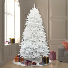 a white christmas tree with presents under it