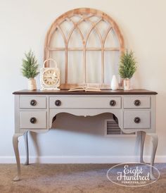 an old desk with a clock and plants on it