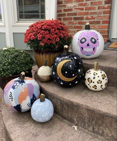 painted pumpkins sitting on the steps in front of a house