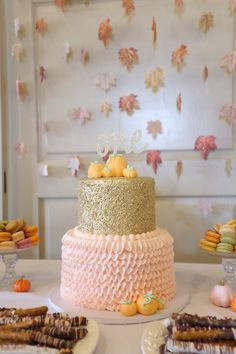 a three tiered cake sitting on top of a table next to other desserts