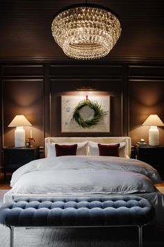 a bedroom with a large bed and chandelier