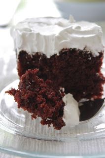 a cake with white frosting and chocolate sprinkles sitting on a plate