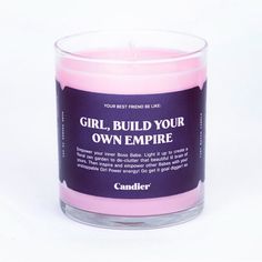 a pink candle with the words girl, build your own empire on it